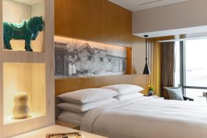 a bedroom with a bed with a green horse on the wall at Renaissance Beijing Wangfujing Hotel in Beijing
