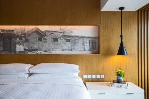 a bedroom with a bed with a picture on the wall at Renaissance Beijing Wangfujing Hotel in Beijing