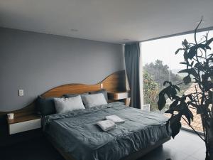 um quarto com uma cama e uma grande janela em Khách Sạn Greenhills em Xuan An