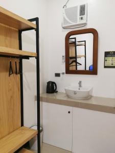 W łazience znajduje się umywalka i lustro. w obiekcie E&R Airport Hotel w mieście Dumaguete
