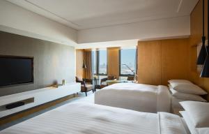 a hotel room with two beds and a flat screen tv at Renaissance Beijing Wangfujing Hotel in Beijing +41 photos