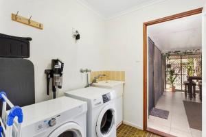 a laundry room with a washer and dryer at Casa Bella in Bongaree