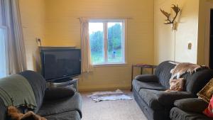 Brunswick的住宿－Ratamarumaru Cottage Farm Stay，客厅配有两张沙发和一台电视