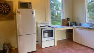 uma cozinha com um frigorífico branco e um lavatório em Ratamarumaru Cottage Farm Stay em Brunswick