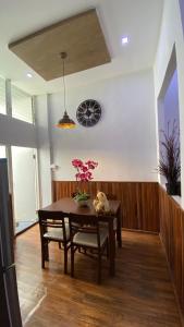 una sala da pranzo con tavolo e orologio sul muro di The Loft Living Space a Samut Prakan