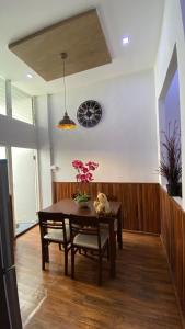 a dining room with a table and a clock on the wall at The Loft Living Space in Samut Prakan