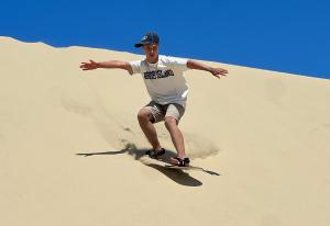 a man riding a skateboard down a sand hill at Sandpiper Shores in Florence