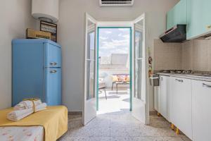 een keuken met een blauwe koelkast en een tafel bij House with Amazing Sea View in Polignano a Mare