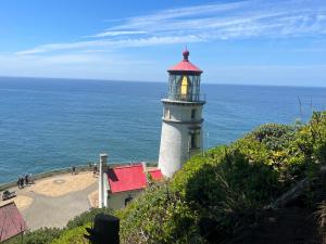 a lighthouse sitting on top of a hill next to the ocean at Sandpiper Shores in Florence