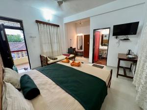 a bedroom with a large bed and a living room at Fatima Guest House in Baga