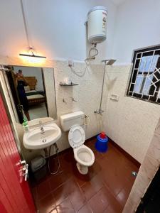 a bathroom with a toilet and a sink at Fatima Guest House in Baga