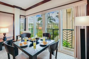 a dining room with a table and chairs and a balcony at Condos in Waipouli Beach Resort in Kapaa