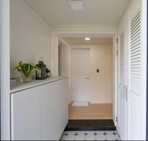 cocina con armarios blancos y suelo de baldosa blanco y negro en Jois House, en Jeju 16 fotos más