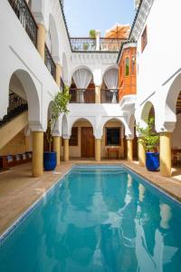 a pool in the courtyard of a building at Riad Berenssi in Marrakech