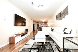 a living room with a white couch and a tv at Hidden Gem in Philadelphia