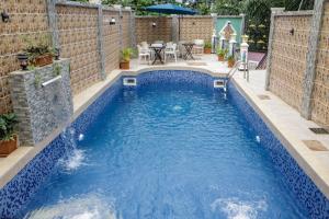- une piscine à débordement avec un mur en briques et de l'eau bleue dans l'établissement Hôtel The Place, à Yaoundé