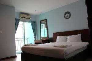 una camera da letto con un letto grande e una finestra di The DEVA a Patong Beach