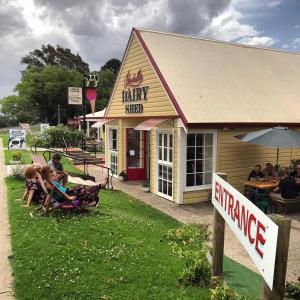 a drink shop with people sitting outside of it at Bodalla Dairy Shed Guest Rooms in Bodalla