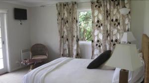 a bedroom with a large bed and a window at Bodalla Dairy Shed Guest Rooms in Bodalla