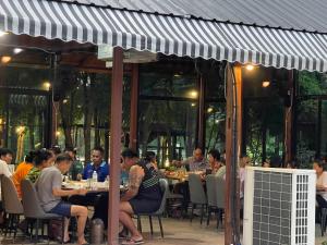 Tha Boพบรักรีสอร์ท Pobruk resort的一群人坐在餐厅的桌子旁