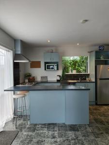 a kitchen with blue cabinets and a counter top at Alice House in Auckland +7 photos