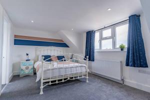 a bedroom with a white bed and a window at Charming 3 BR in Folkestone! in Folkestone