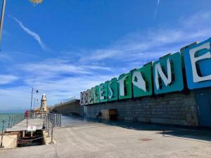 un muelle con una señal que lee el océano en Charming 3 BR in Folkestone! en Folkestone