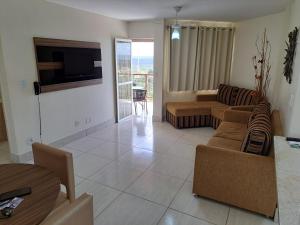 ein Wohnzimmer mit einem Sofa und einem TV in der Unterkunft Império Romano - Splash e Acqua Park in Caldas Novas