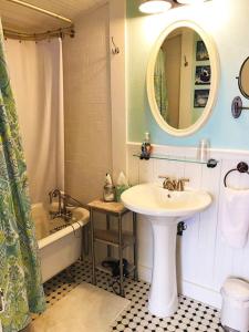 a bathroom with a sink and a tub and a mirror at Aunt Hattie's Farmhouse in Llano