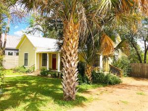 a palm tree with a giraffe trunk in front of a house at Aunt Hattie's Farmhouse in Llano