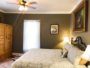 um quarto com uma cama e uma ventoinha de tecto em Aunt Hattie's Farmhouse em Llano