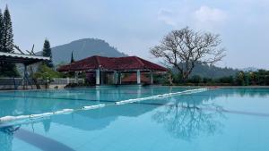 - une piscine avec un kiosque en arrière-plan dans l'établissement Green Hill Resort Kemuning, à Panyaweuyan