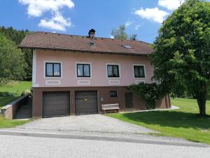 ein Haus mit zwei Garagentüren und einer Bank in der Unterkunft Ferienhaus Schöller in Schönbach