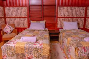 a room with two beds and a chair in it at Tahals Holiday Villas in Nadi