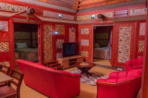 sala de estar con muebles de color rojo y TV en Tahals Holiday Villas en Nadi
