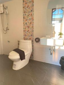 La salle de bains est pourvue de toilettes blanches et d'un lavabo. dans l'établissement My Heaven Resort, à Trang