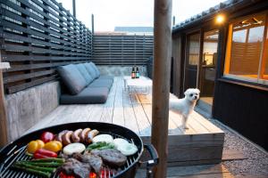 ein Hund steht auf einer Terrasse mit einem Grill und Gemüse in der Unterkunft AKIYA nehemiah - Vacation STAY 84870 in Awaji