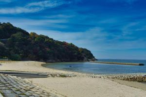 einen Strand mit einem Pier im Wasser in der Unterkunft AKIYA nehemiah - Vacation STAY 84870 in Awaji