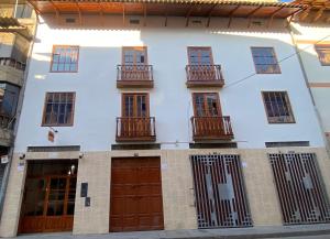 a white building with brown doors and windows at La Pascana Hospedaje in Cajamarca