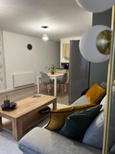 ein Wohnzimmer mit einem Sofa und einem Tisch in der Unterkunft Appartement Cosy in La Châtre