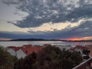 a view of a city with the water and clouds at Apartment Tomi in Brodarica