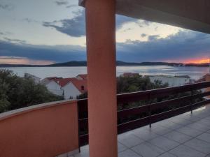 een balkon met uitzicht op de oceaan bij zonsondergang bij Apartment Tomi in Brodarica