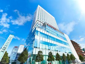 a tall glass building with trees in front of it at Lotte City Hotel Kinshicho in Tokyo