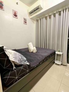 a bed in a room with a window with curtains at 1 BR South Residences SM Southmall Netflix / Alexa in Manila