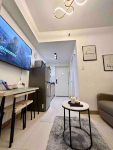a living room with a tv and a couch and a table at 1 BR South Residences SM Southmall Netflix / Alexa in Manila