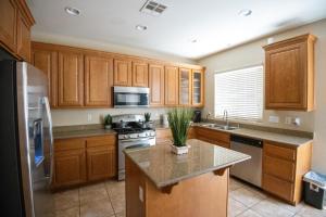 a kitchen with wooden cabinets and stainless steel appliances at Large 3BR King Suite Moments Away From Strip in Las Vegas
