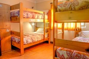 a room with three bunk beds in a house at Bear Packer Hostel in Cusco