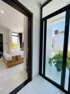 une chambre avec un lit et une grande fenêtre dans l'établissement D & A Homestay Hue, à Hue