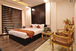 een hotelkamer met een bed en een stoel bij Hotel Kings Inn, Karol Bagh, New Delhi in New Delhi