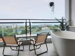 dwa krzesła i stół na balkonie z widokiem w obiekcie Whale Hua Hin - SHA Plus w mieście Hua Hin